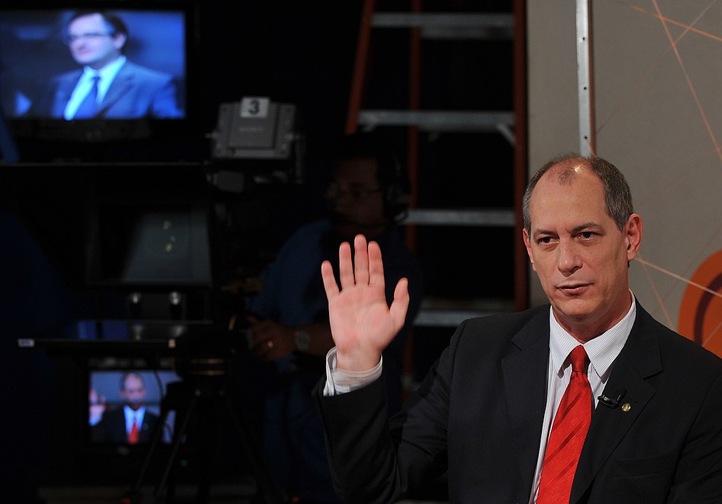 Ciro Gomes com a mão erguida em meio a uma entrevista.