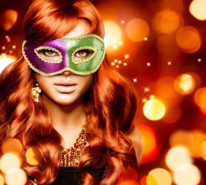 123rf Mulher ruiva com máscara de carnaval rosa e verde.