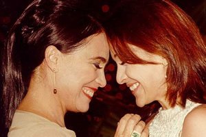 Personagens da novela Por Amor interpretados por Regina e Gabriela Duarte de testas coladas e sorrindo.