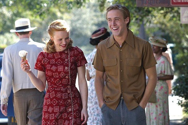 Rachel McAdams como Allie e Ryan Gosling como Noah sorrindo durante uma cena do filme em que andam na rua
