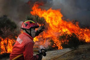 Bombeiro e fogo ao fundo