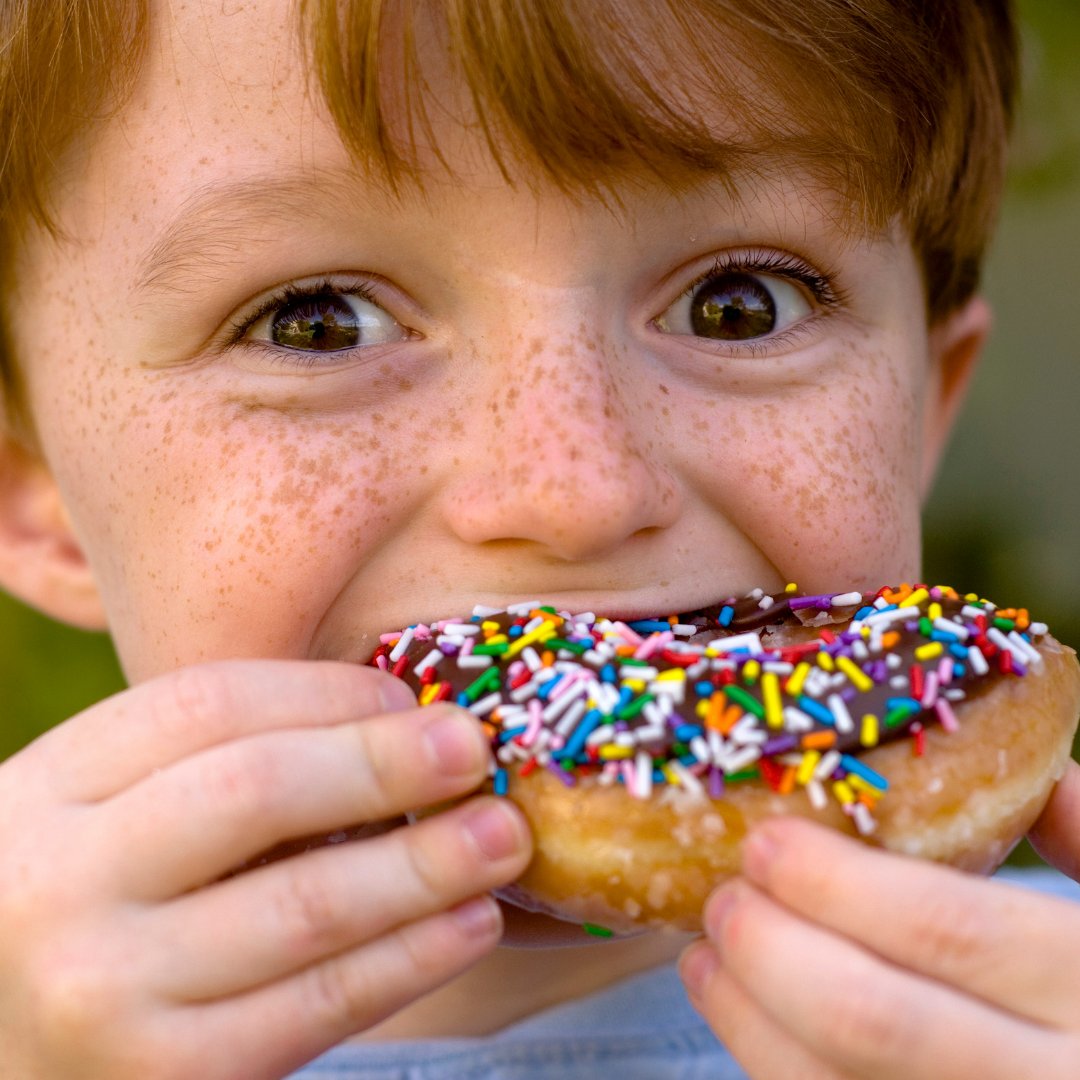 criança comendo donuts