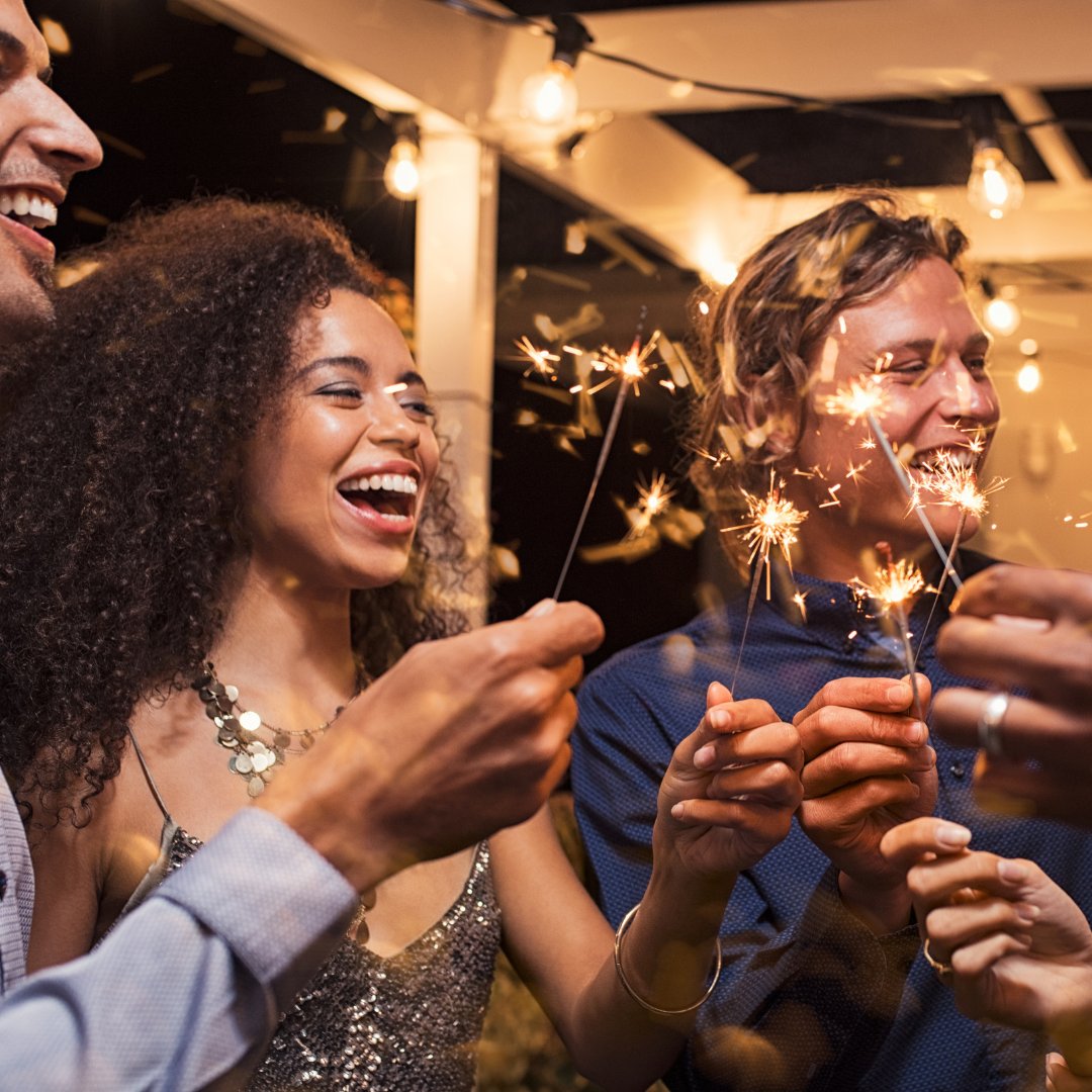 Pessoas comemorando o ano novo com velas estrelas na mão