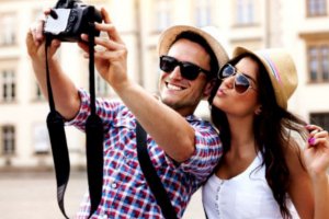 Casal tirando selfie com uma câmera.