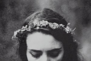 Meio rosto de mulher com coroa de flores em preto e branco