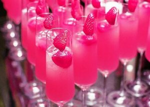 Copo com drink rosa e morangos no topo