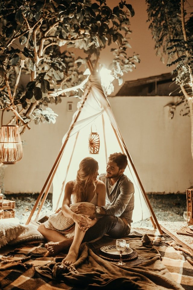 Homem e mulher sentados sob uma tenda