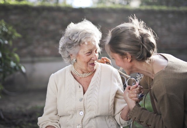 Mulher conversando com uma senhora idosa