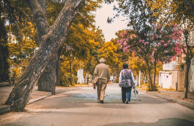 Dois idosos caminhando em um parque