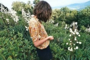 Menina em meio a plantas e flores