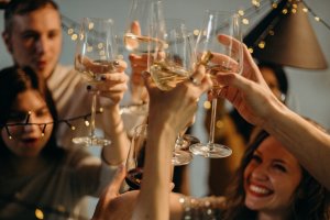 Pexels - cottonbro Pessoas brindando com taças contendo vinho branco.