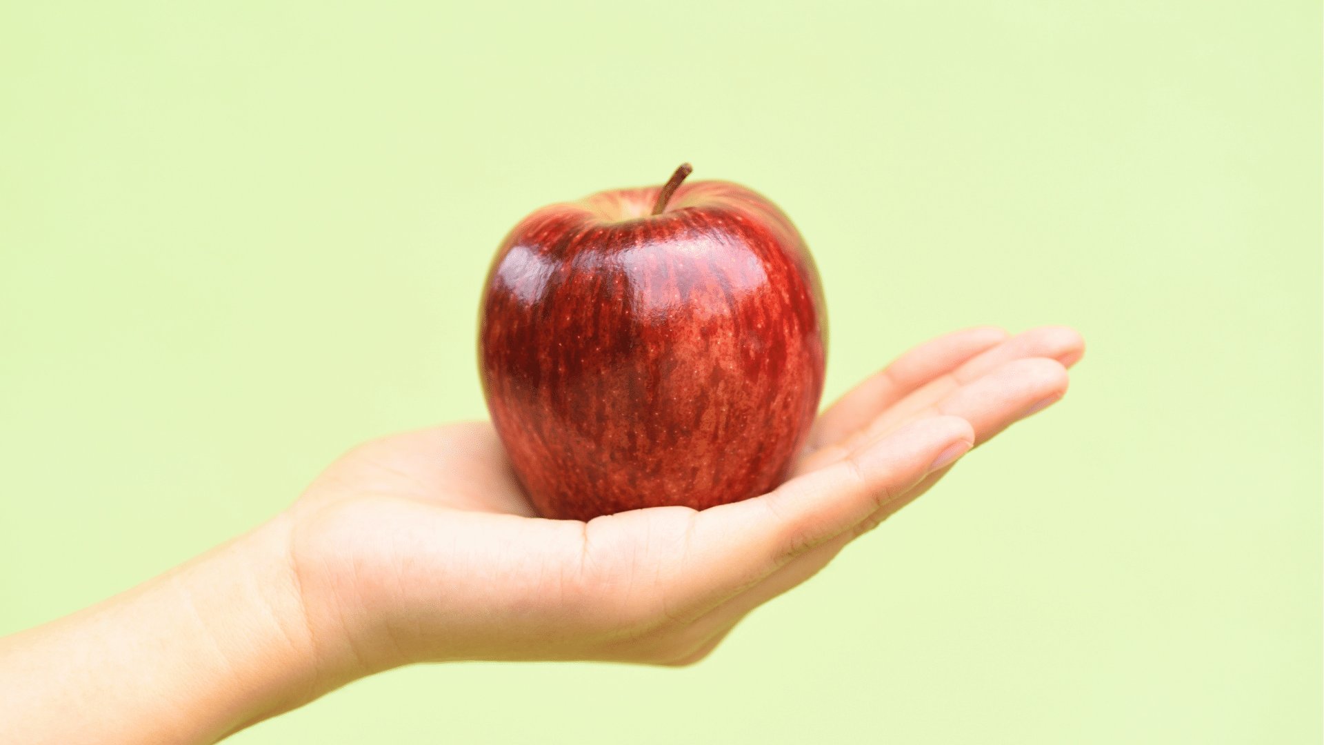 Mão segurando uma maçã