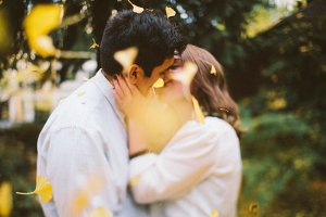 Casal se beijando em meio as pétalas amarelas.