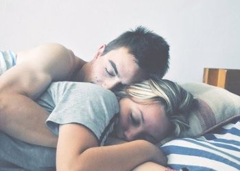 Homem e mulher dormindo de conchinha.