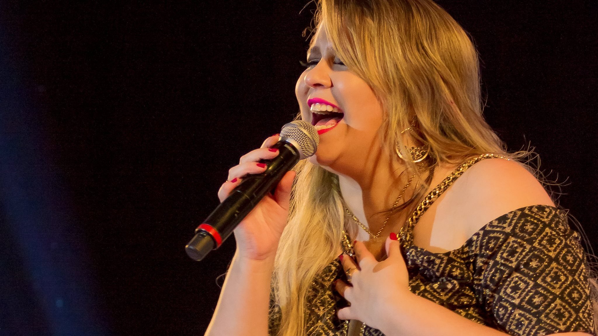 Marília Mendonça cantando feliz em show