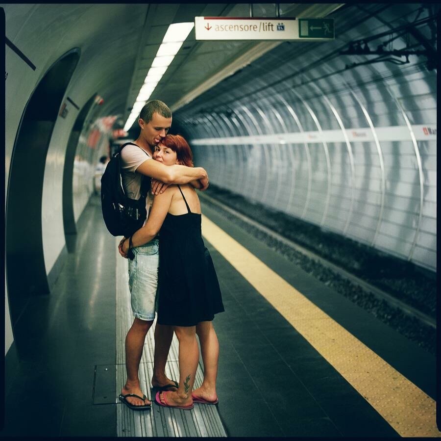 Casal se abraçando na estação de metrô