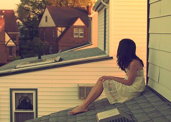 Menina sentada em telhado