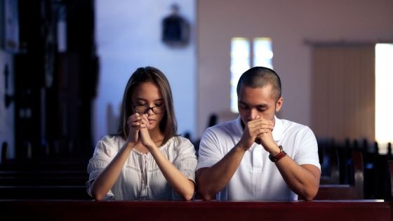 Casal orando em uma igreja