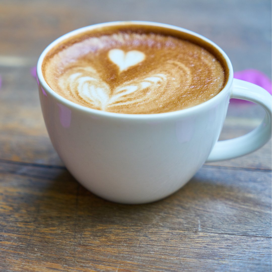 Foto de uma xícara com café com espuma em formato de coração