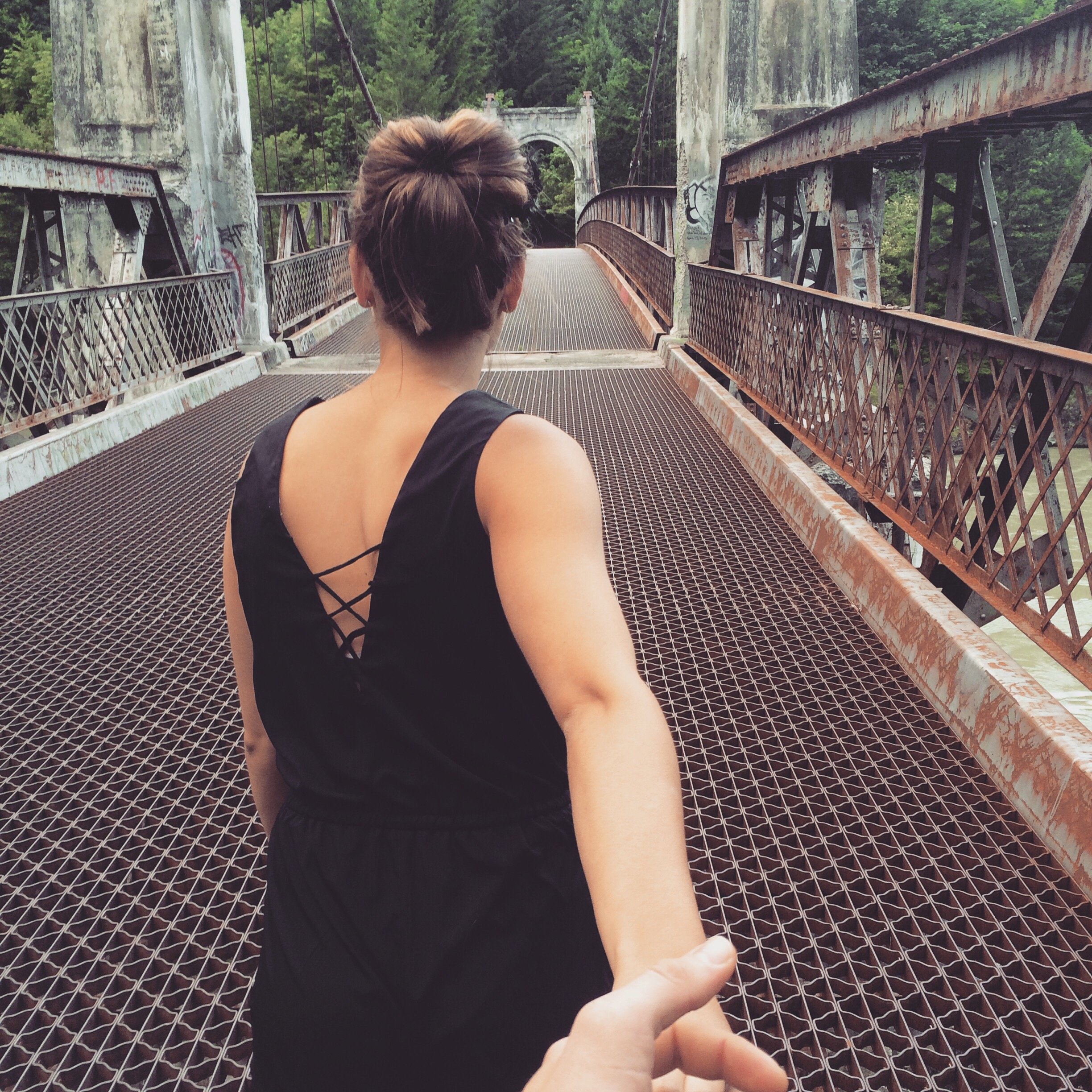 Homem segurando mão de uma mulher na ponte
