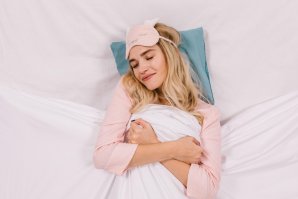 Mulher sentada na cama com mão na cabeça