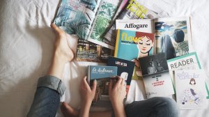 Pessoa sentada na cama com livros espalhados