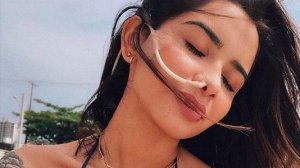 Nara Almeida de olhos fechados em praia
