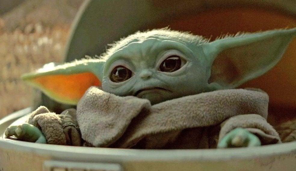 Bebê Yoda sentado em uma cadeira