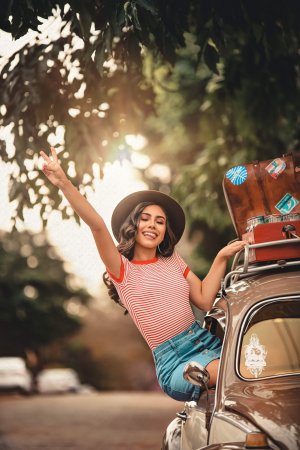 Pexels/Renato Abati Mulher sentada na janela de um carro, com uma mão para cima