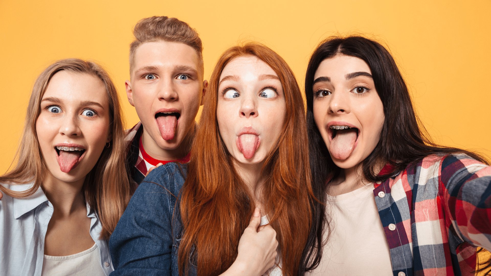 Grupo de amigos de três garotas e um garoto tirando uma selfie com a língua de fora