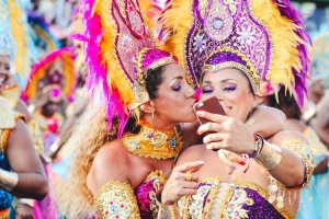 Unsplash Passistas fantasiadas tirando selfie na avenida.