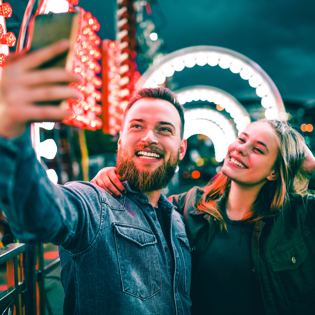 Casal tirando Selfie em um parque de diversões
