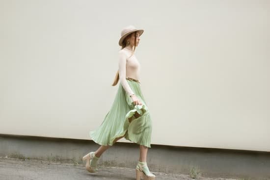Mulher andando na rua usando saia e chapéu