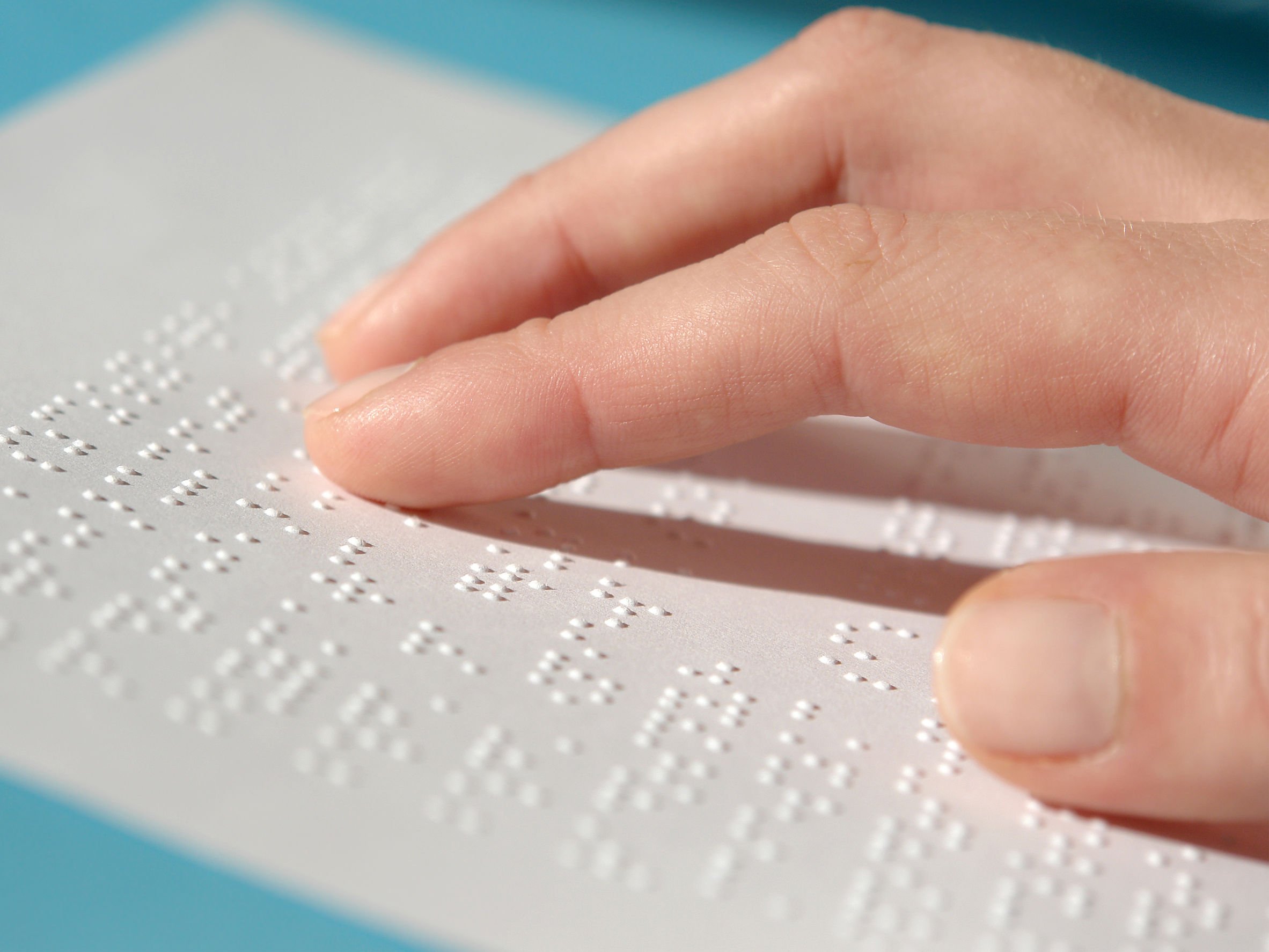 Mão fazendo leitura em braille.
