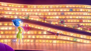 Reprodução Disney Pixar | Giphy Personagem Alegria olhando para painel das memórias da Riley
