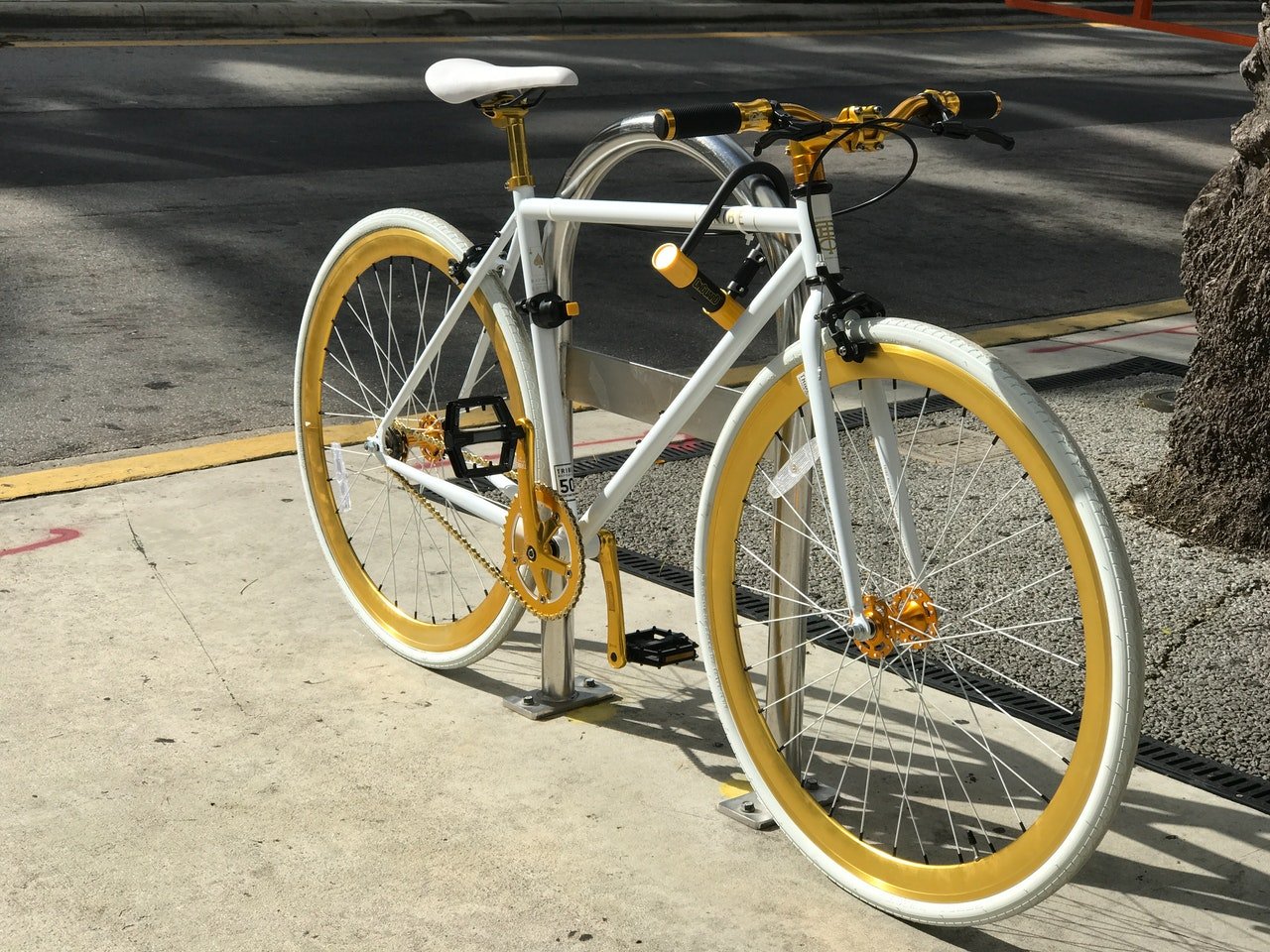 Bicicleta branca com rodas amarelas.