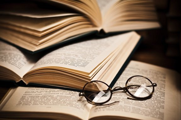 Livros abertos e óculos redondo