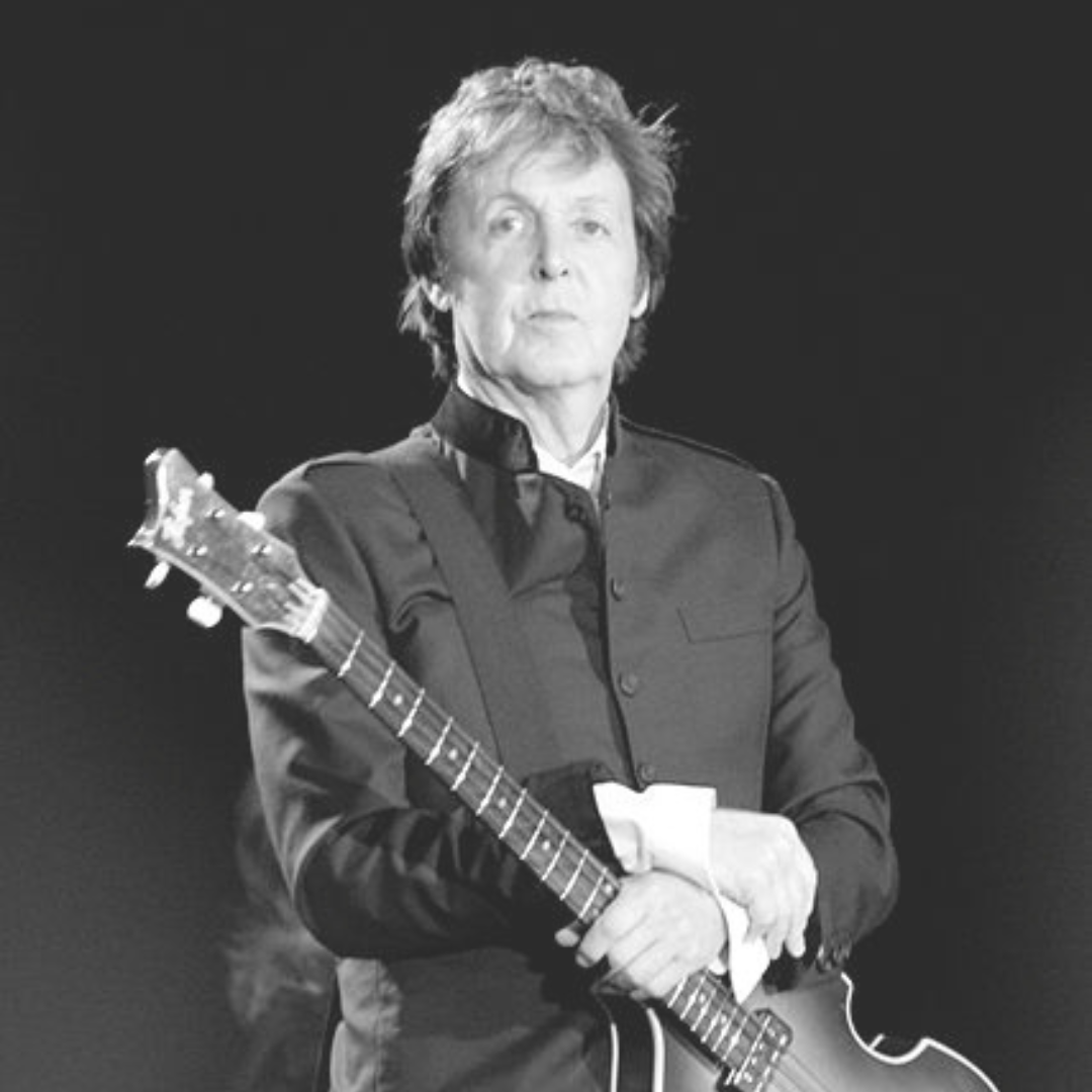 Paul no palco segurando guitarra
