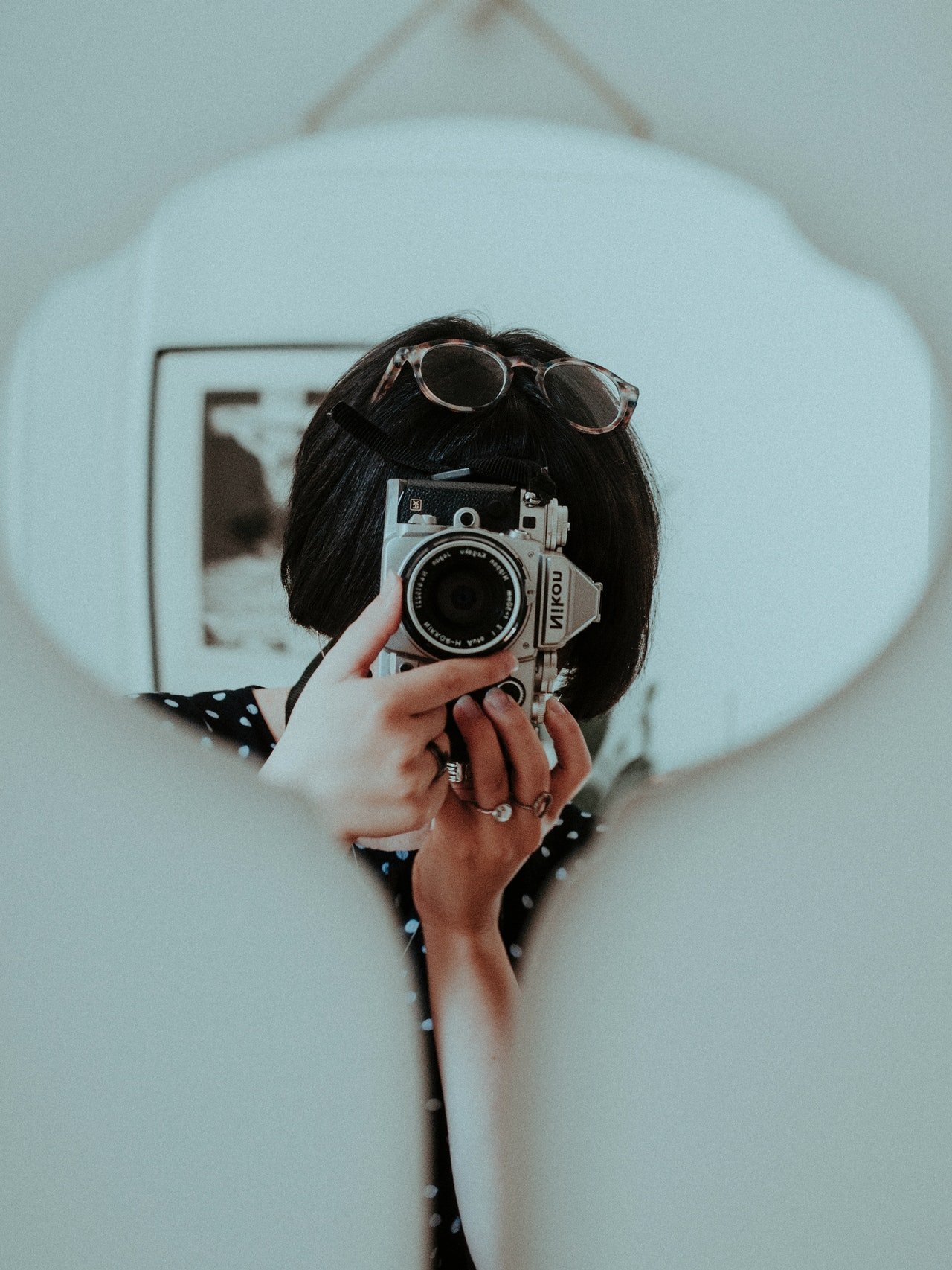 Mulher fotografa a si mesma no espelho.