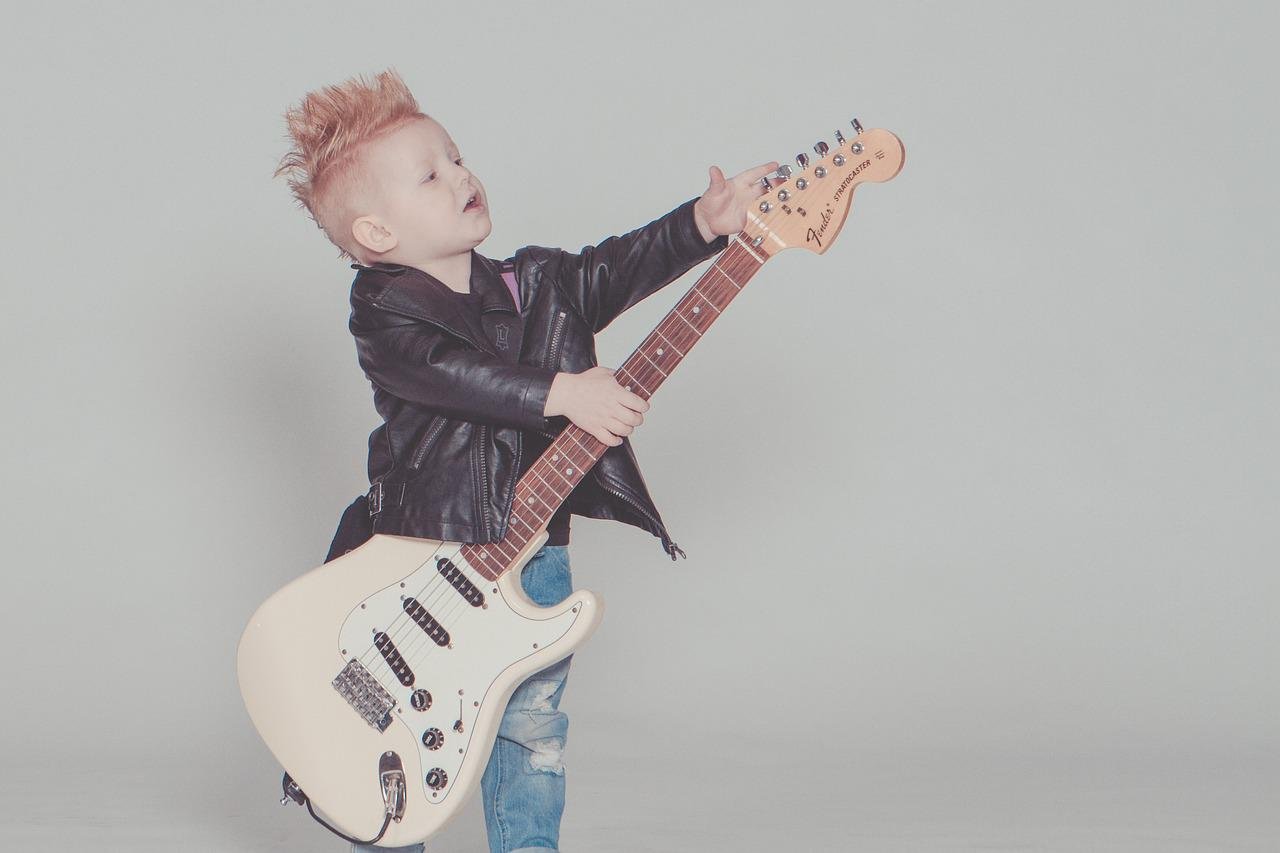 Bebê fantasiado de estrela do rock com guitarra