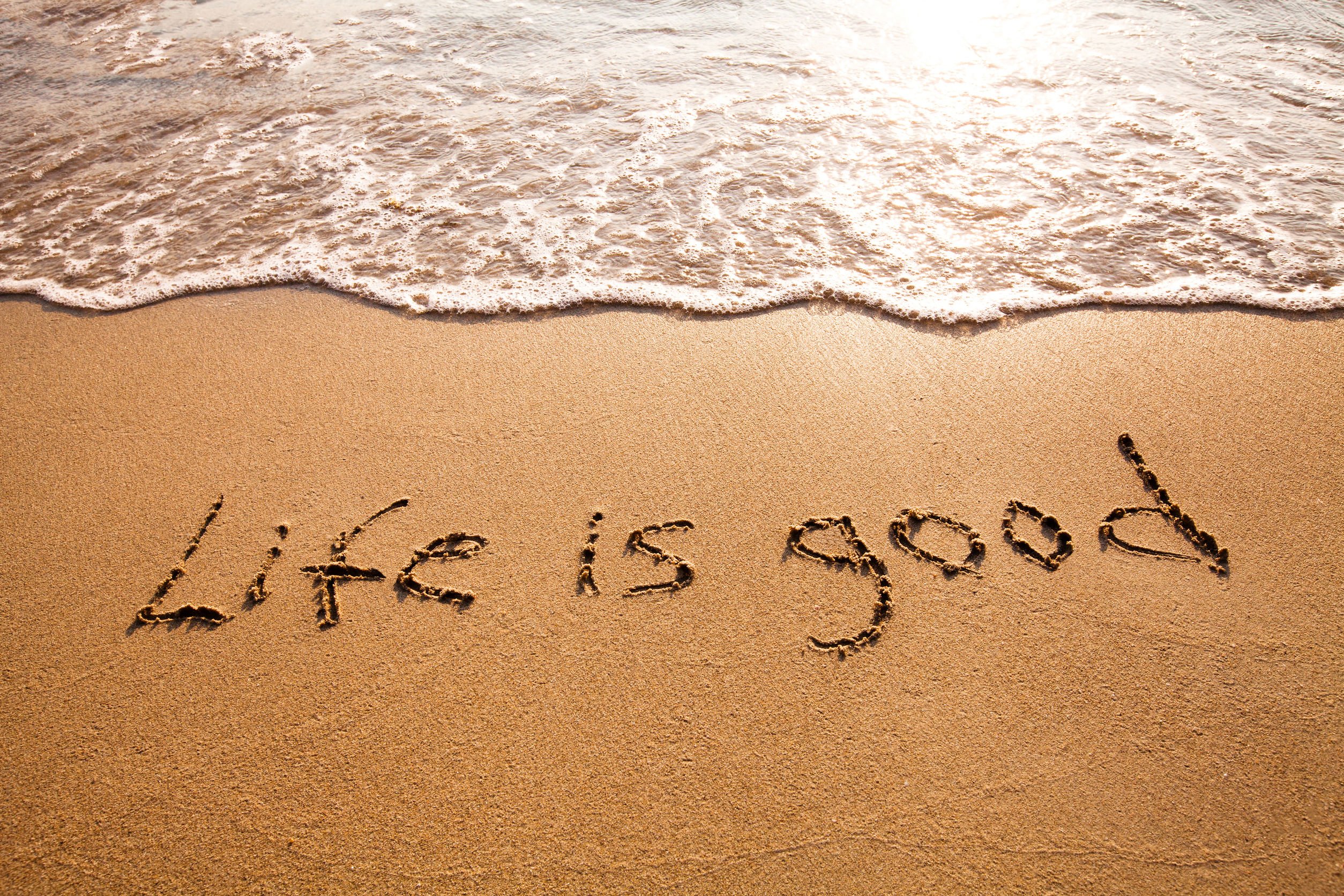 'Life is good' escrito na areia