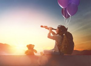 Criança olhando para o céu com um telescópio