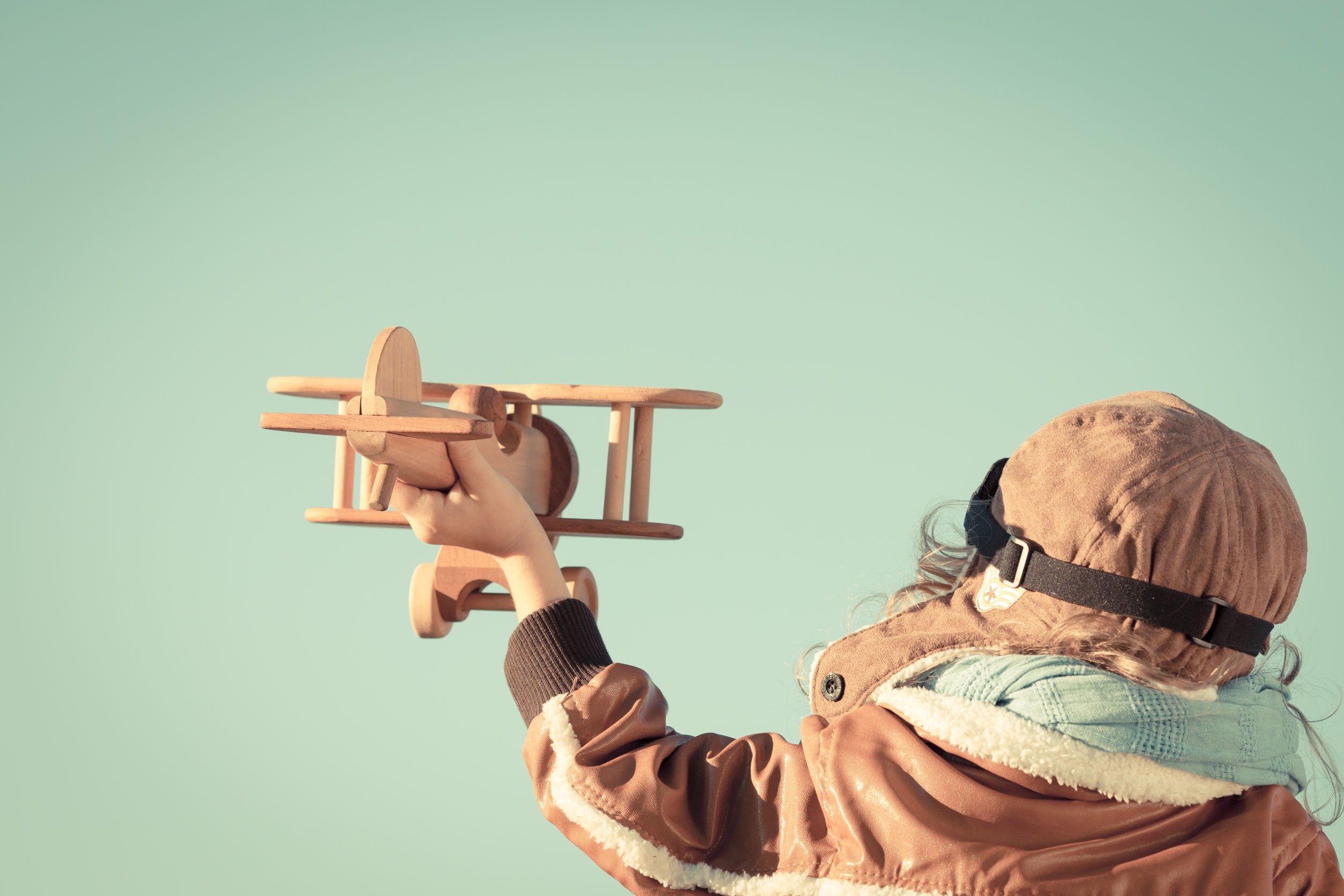Criança com avião de madeira