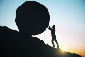Homem arrastando pedra redonda gigante