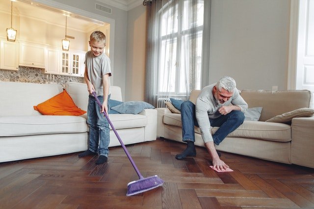 Criança e senhor limpando chão de casa