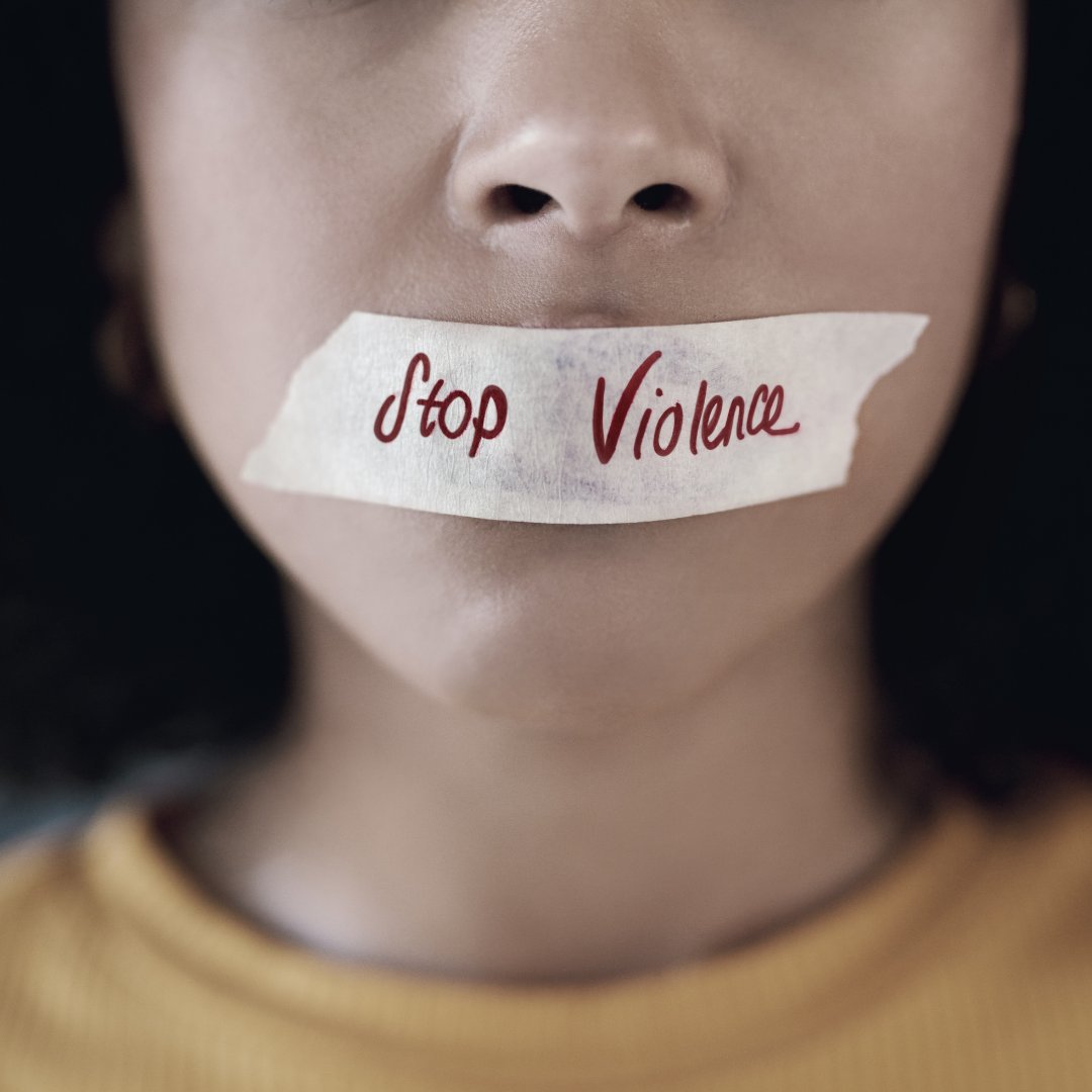 Mulher com o dizer 'Stop violence' (chega de violência) sobre a boca