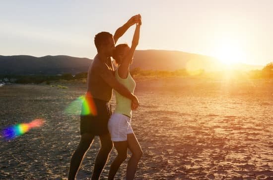 Homem dançando na praia com uma mulher