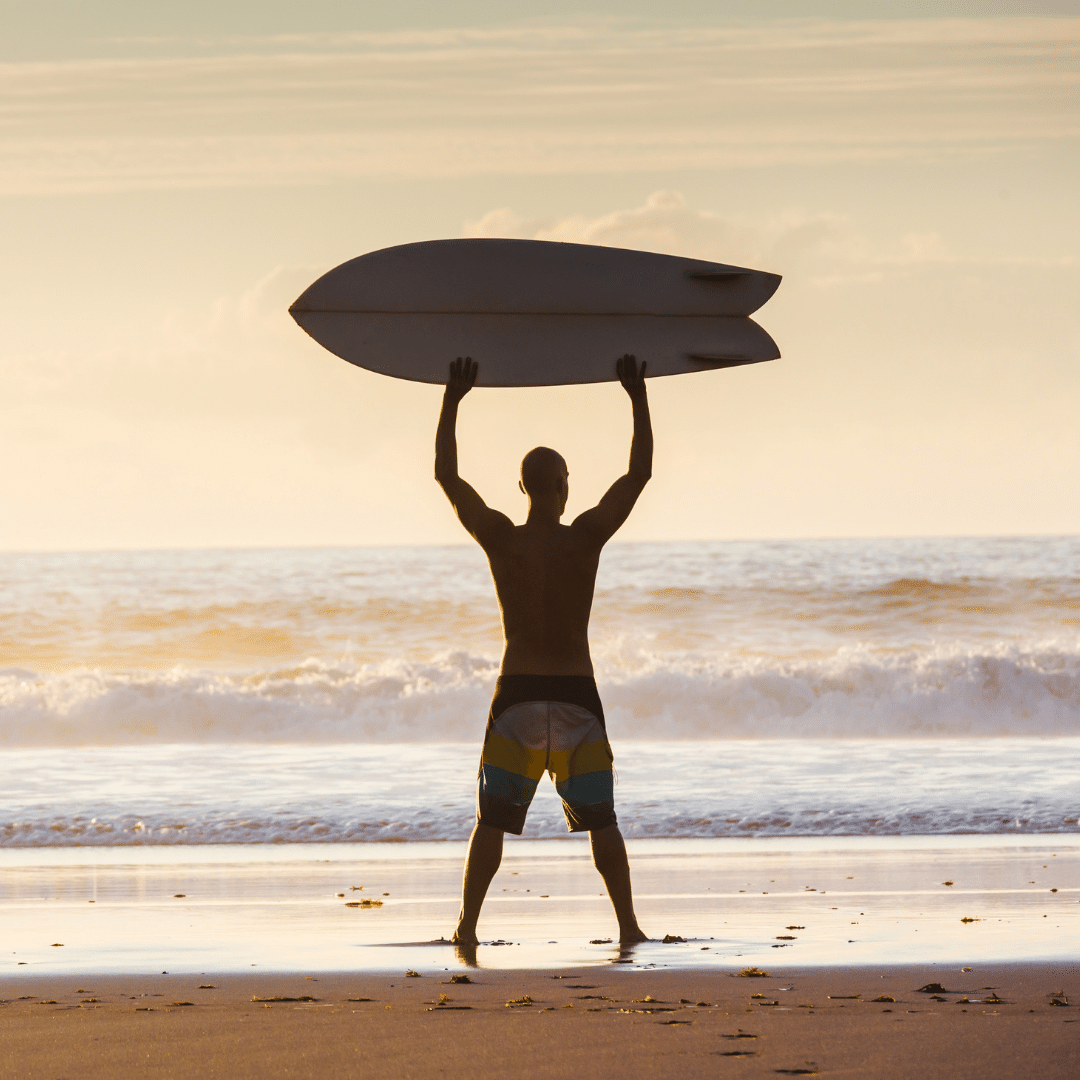 Homem levantando prancha de surf