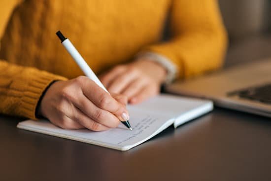 Mulher escrevendo em um caderno com caneta