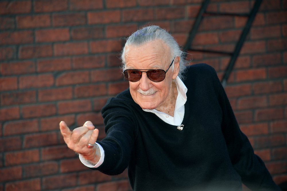 Stan Lee fazendo sinal do Homem Aranha com as mãos